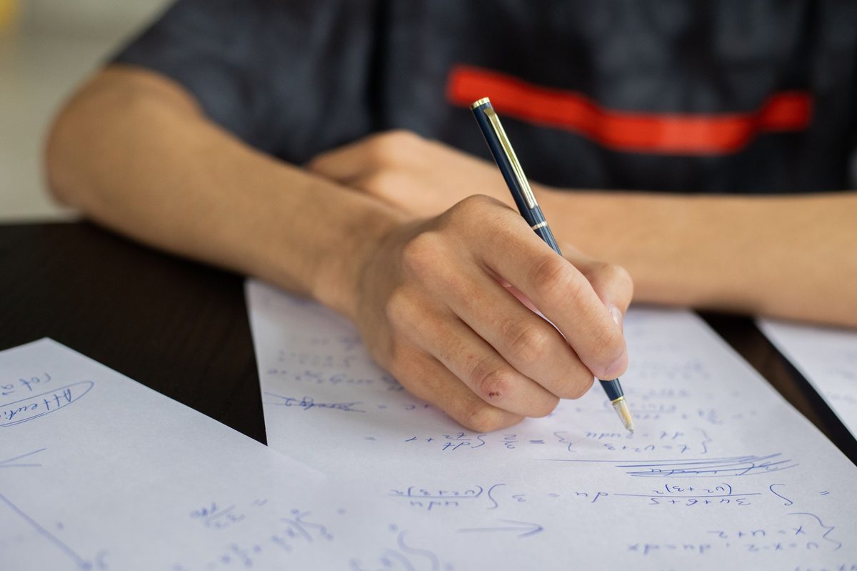 A student working through math problems by hand